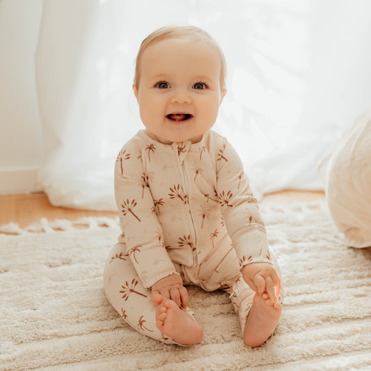 Little baby wearing the winter onesie in the Desert Palm design.