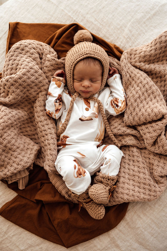 This Lion Growsuit in white organic fabric with adorable lions design. Matching Beanie can be bought separately