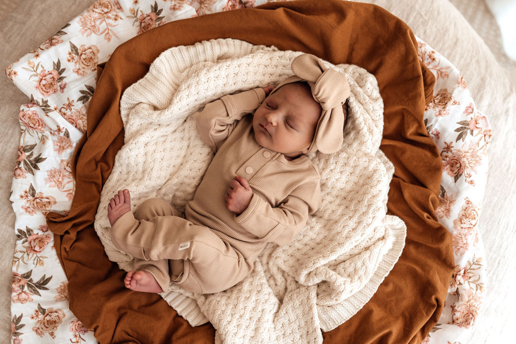 Baby shown in beautiful neutral Pebble colour growsuit