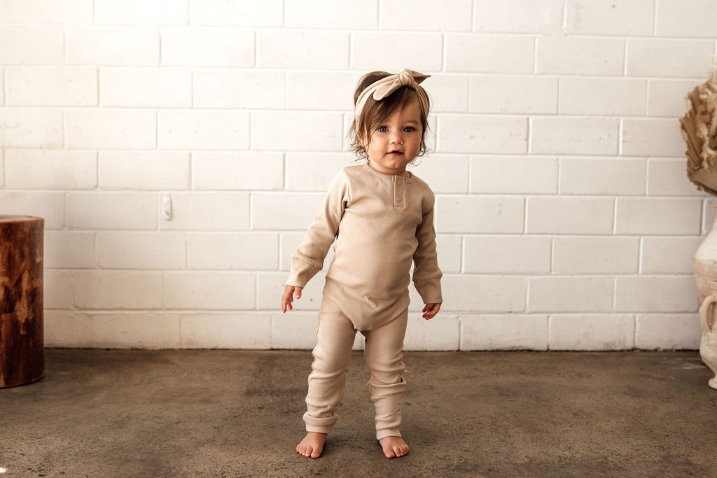 Toddler shown in beautiful neutral Pebble colour growsuit