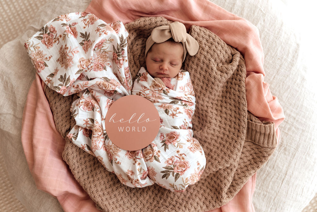 newborn swaddled int he rosette muslin wrap with the 'hello world' card