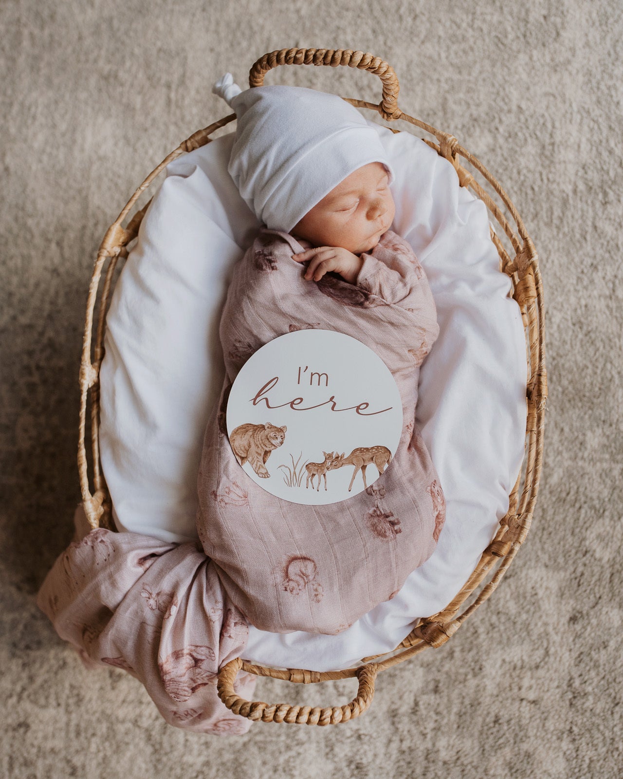 Newborn swaddled in the Woodland Muslin Wrap with the 'I'm Here' card